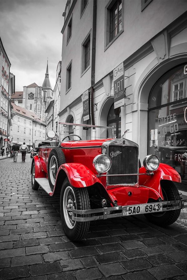 پوستر ماشین قدیمی قرمز در خیابان سنگ فرش سیاه و سفید